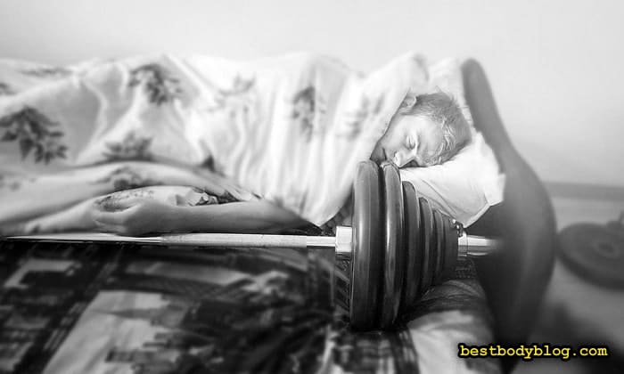Головний недолік звичайних тренувальних програм — втомлений чоловік спить у ліжку поряд зі штангою