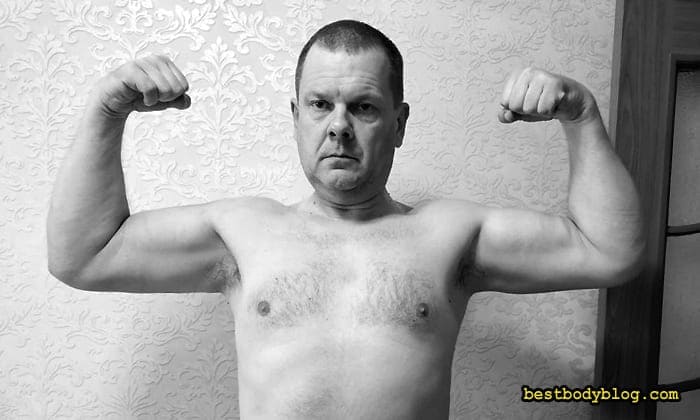 Чоловік середнього віку демонструє біцепси як результат силових тренувань після 40 років